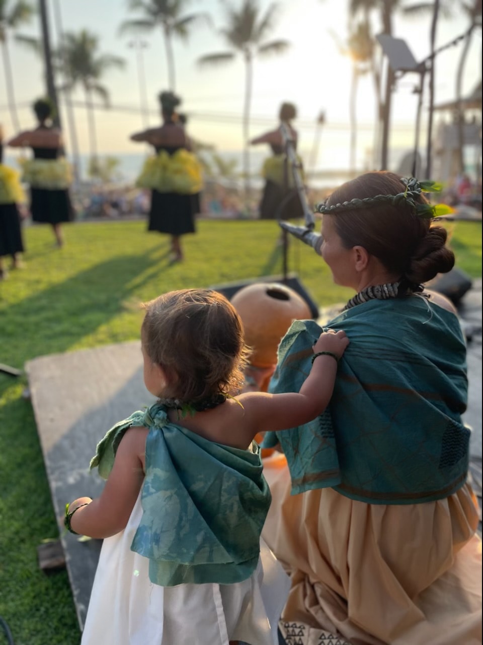 Young haumana watching a sunset hula performance at Coconut Grove Marketplace in Kailua-Kona